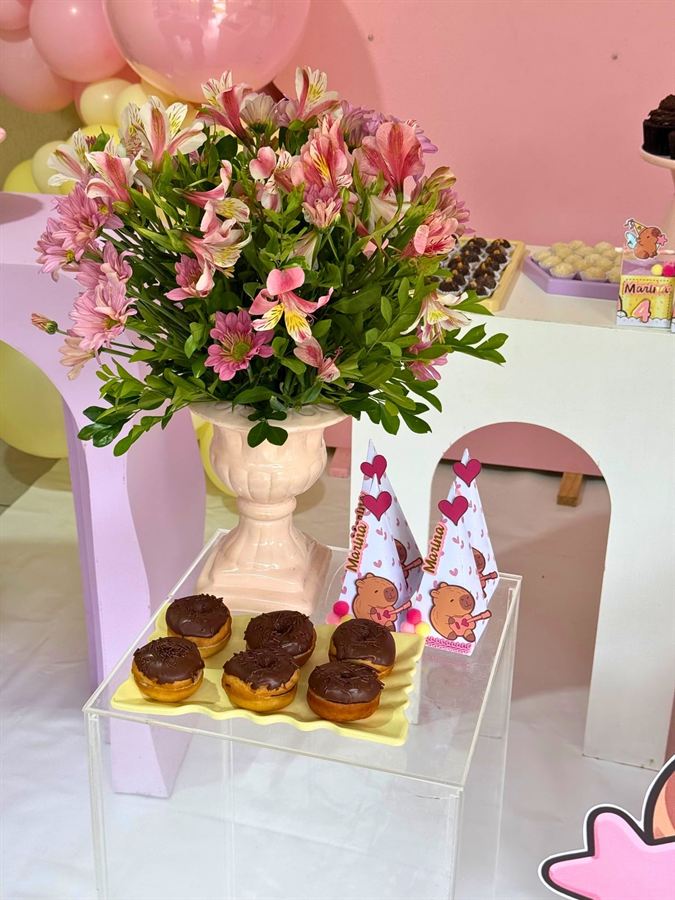 Mesa de festa com mini donuts e flores montada pela Doce Mel